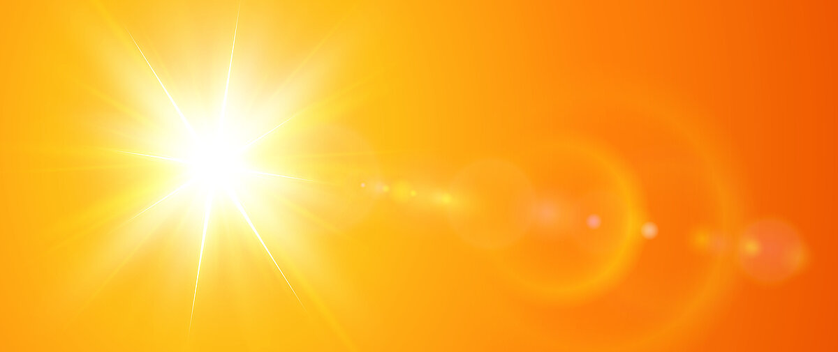 Sonne mit grellem Lichtschein auf leuchtend orangefarbenem Hintergrund als Symbol für Sommerhitze.
