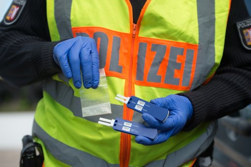 Polizist in Warnweste mit Drogentestkit