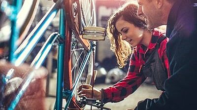 Eine Frau und ein Mann schauen sich ein Fahrrad an