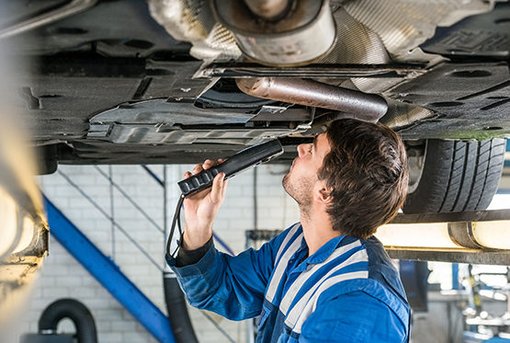 Ein Mechaniker schaut unter ein Auto