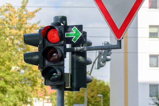 Verkehrsschild Grüner Pfeil an einer roten Ampel