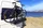 Zwei Fahrräder auf einem Heckträger an einem Wohnmobil, geparkt direkt am Meer unter blauem Himmel – Symbol für Campingurlaub, Flexibilität und Fahrradtransport beim Reisen.