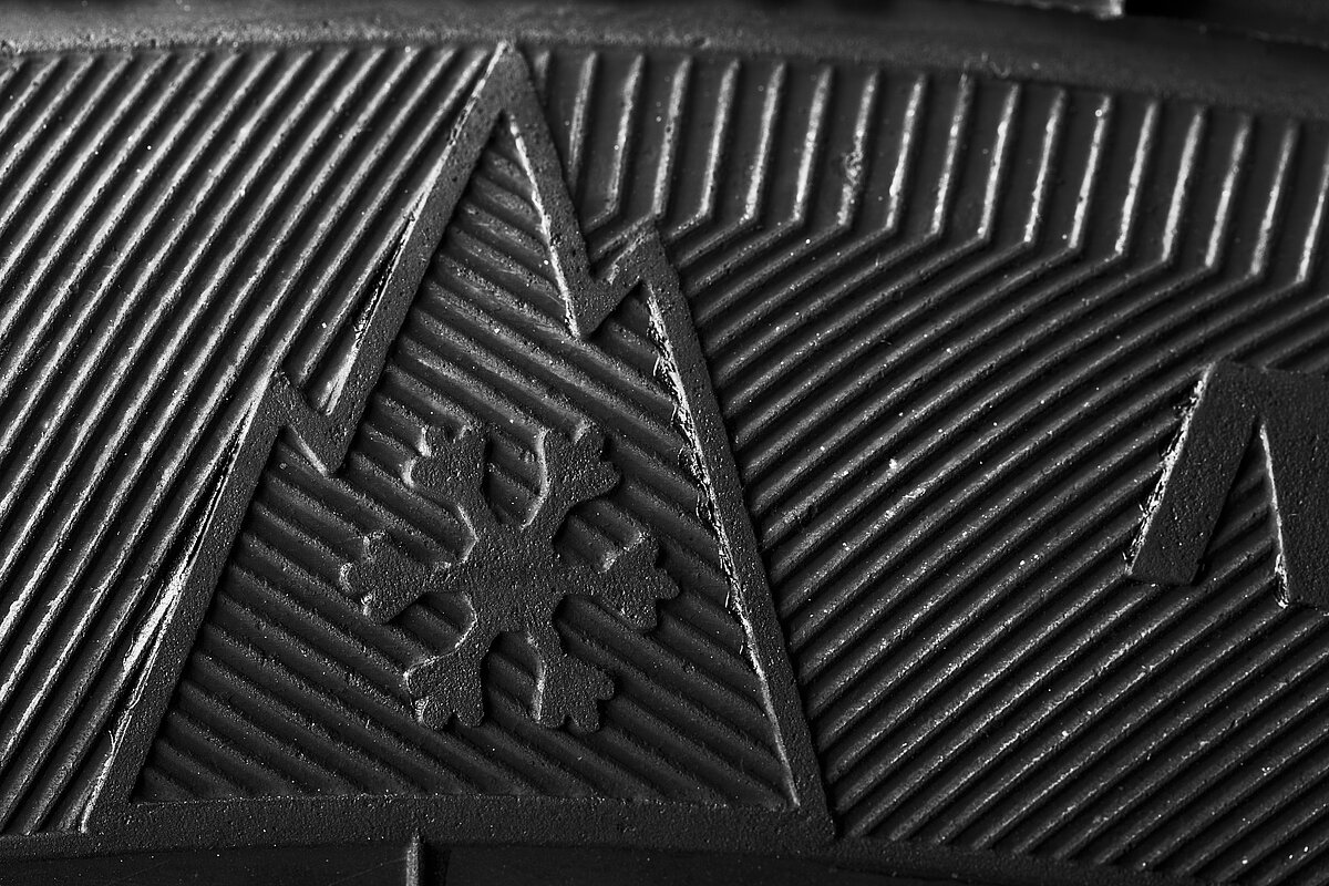 Alpine-Symbol (Berg mit Schneeflocke) auf einem Autoreifen – Kennzeichnung für zugelassene Winter- und Ganzjahresreifen.