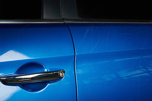 Ein blaues Auto mit Kratzern an der Seite