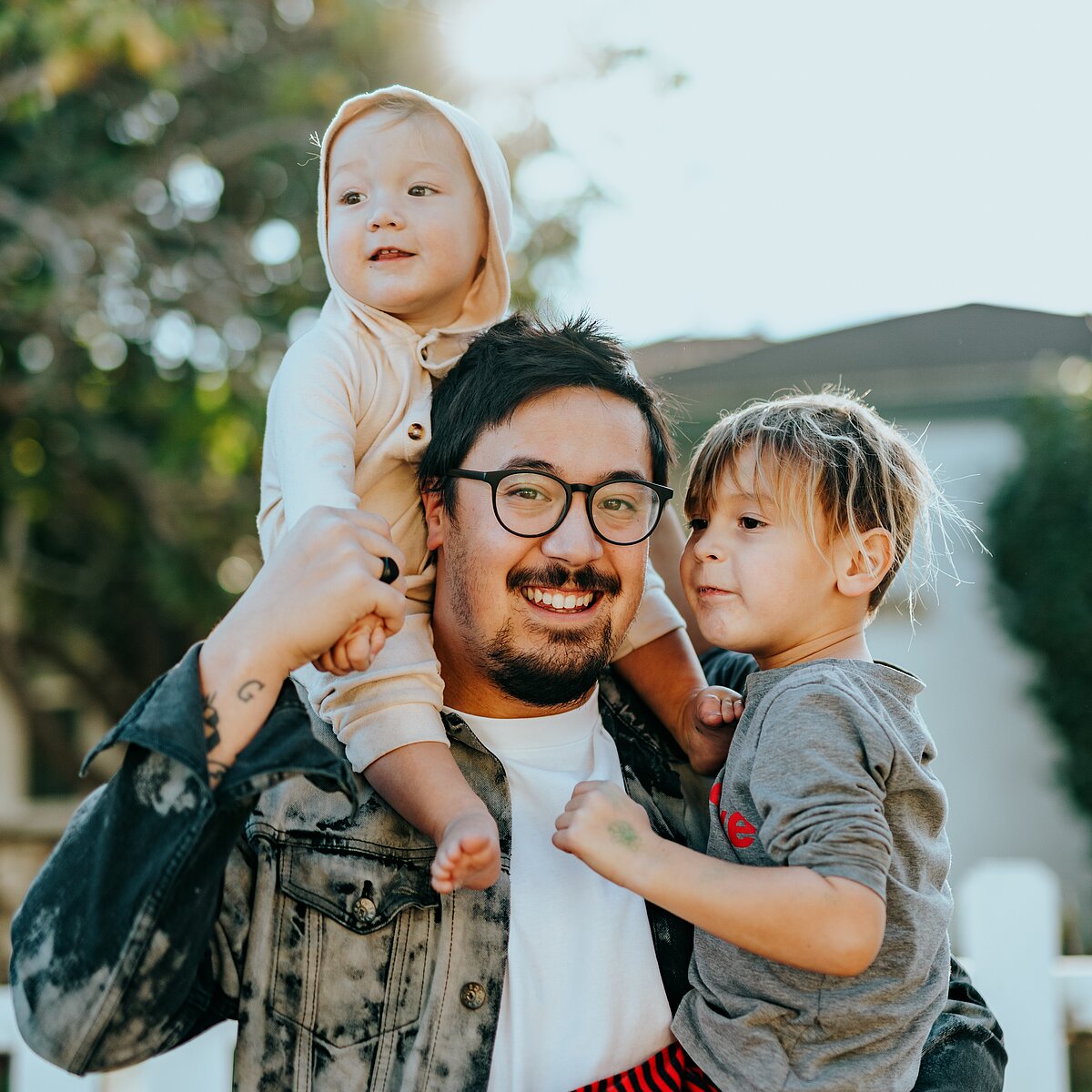 Vater mit 2 Kindern auf dem Arm