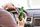 Mann sitzt in einem Auto und hält eine Bierflasche in der Hand