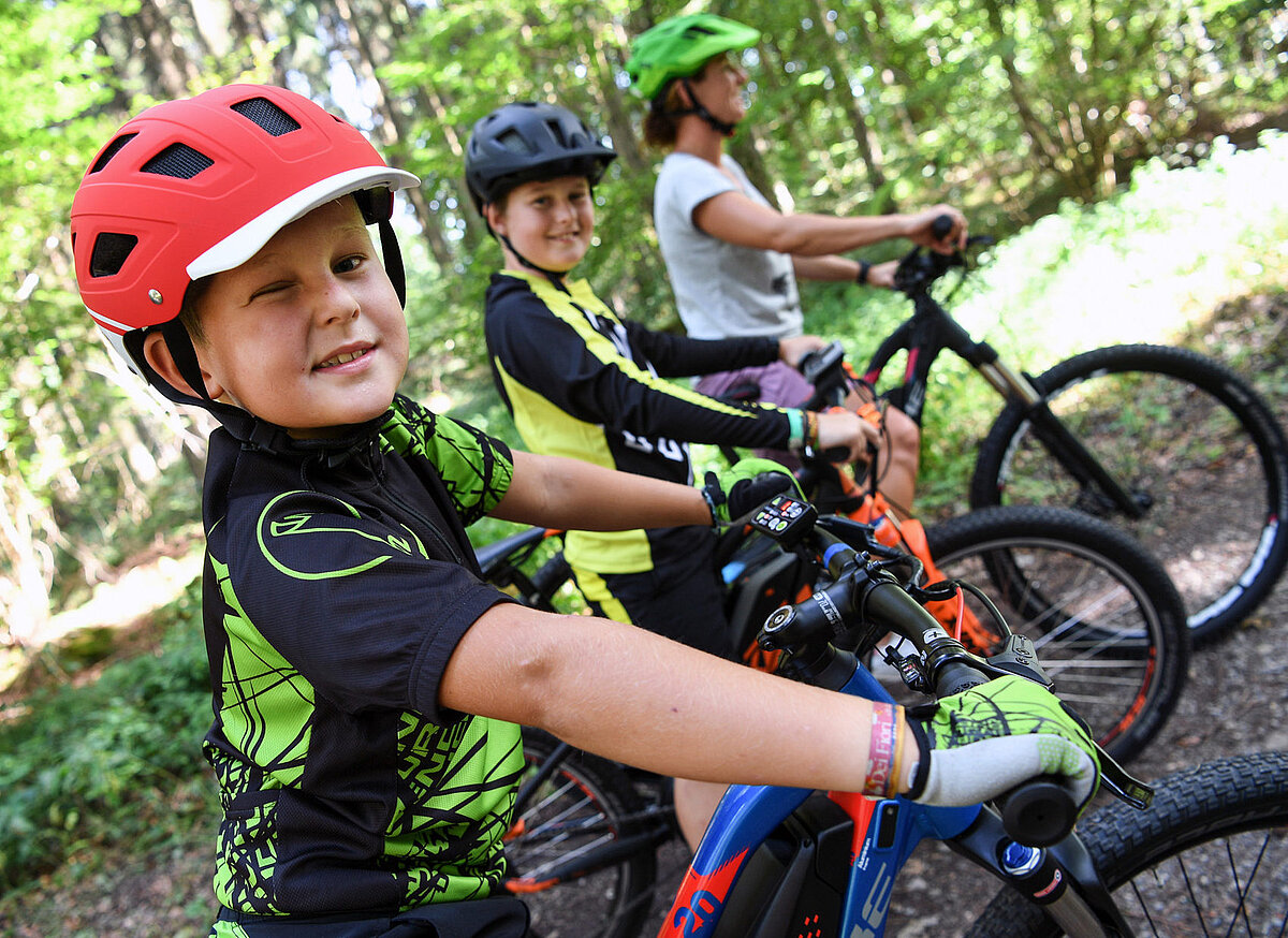 Kinder fahren mit dem Fahrrad auf einem Waldweg