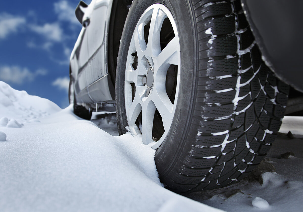 blaues Auto fährt durch den Schnee