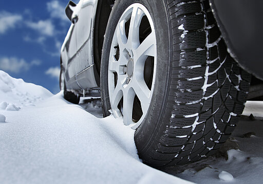 blaues Auto fährt durch den Schnee