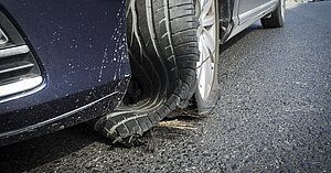 Zerstörter Pkw Reifen nach Reifenplatzer auf der Autobahn.