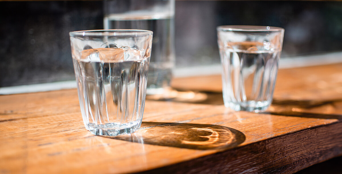 gläser mit wasser stehen auf einem holztisch