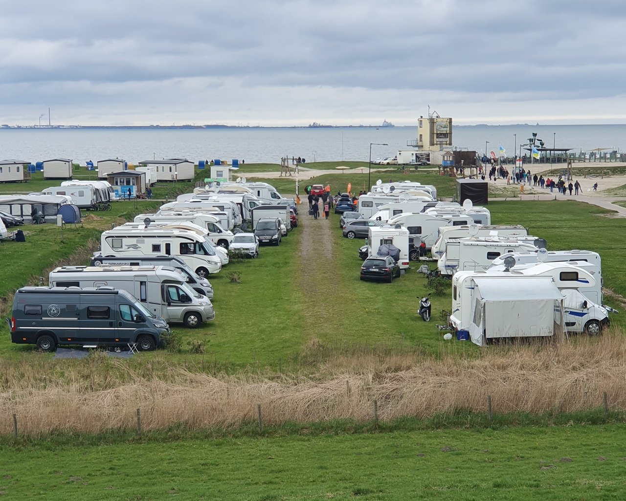 Campingplatz am Meer mit in Reihe stehenden Wohnmobilen