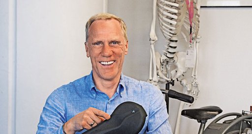 Mann mit einem Fahrradsattel in der Hand