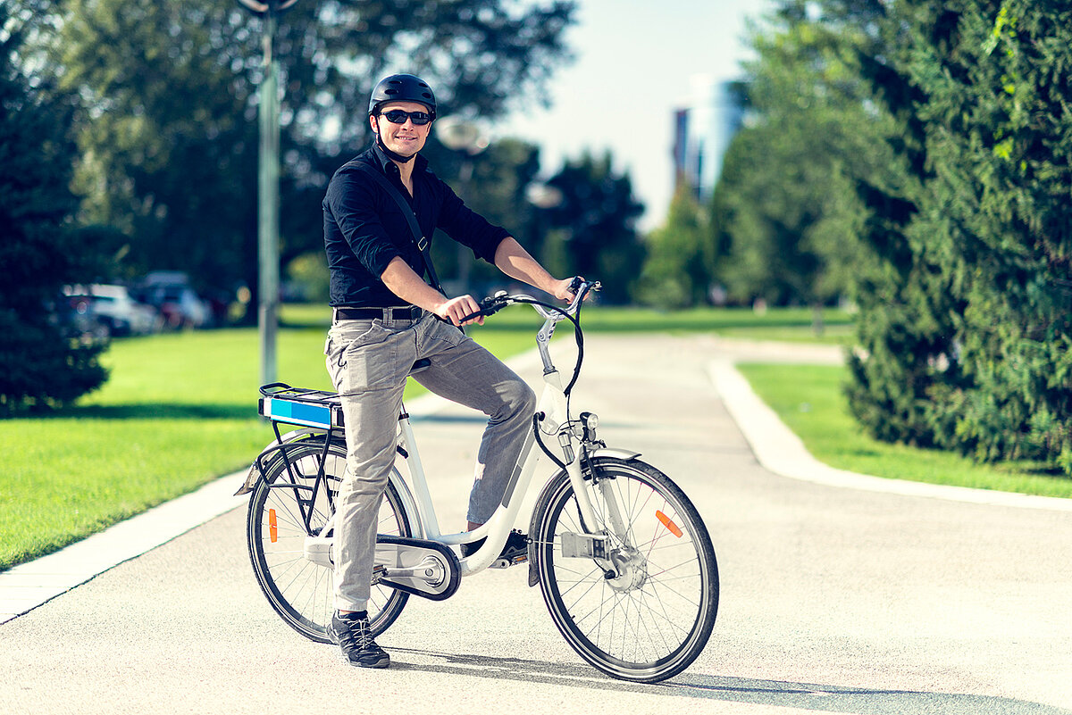 Mann mit einem Fahrradhelm sitzt auf einem Fahrrad