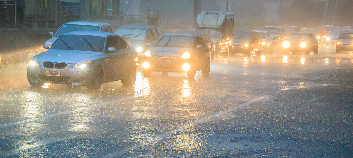 Autos fahren durch Platzregen und Gewitter auf einer Straße