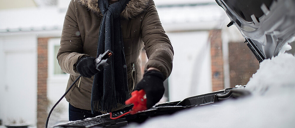 Frau gibt Starthilfe im Winter