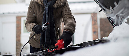Frau gibt Starthilfe im Winter