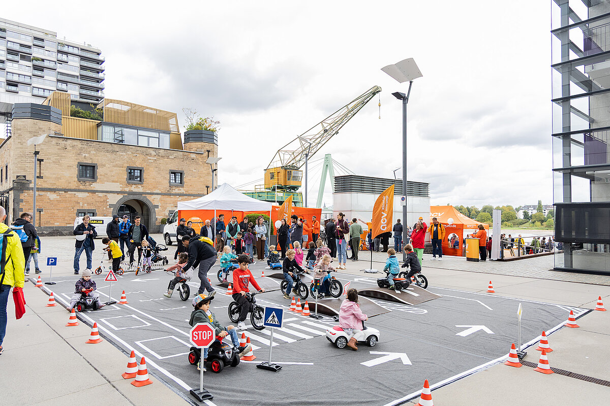 gruppe von kindern und erwachsenen auf einem verkehrsparkours am rheinaufhafen in köln