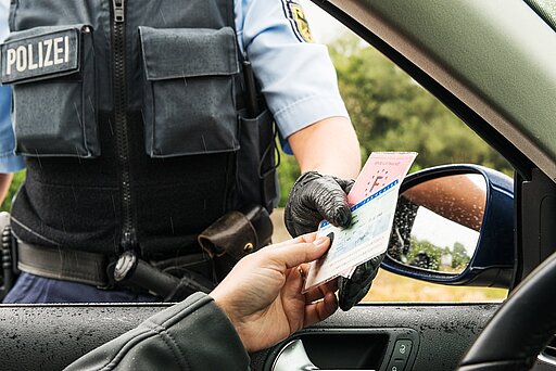 Mann im Auto gibt Polizist seinen Führerschein