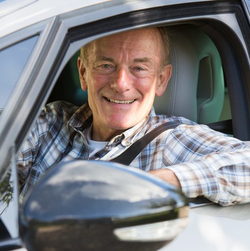 Ein älterer Herr fährt mit seinem Auto