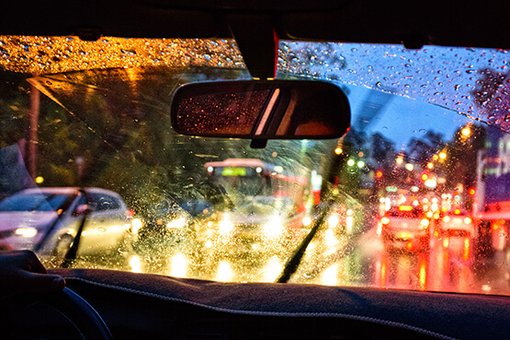 Ein Auto fährt im Dunkeln durch den Regen