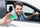 Ein Mann sitzt im Auto und hält eine grüne Karte hinaus