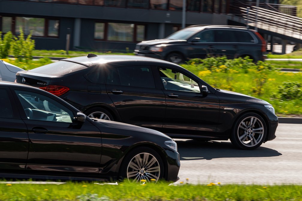 Schwarzes Auto überholt innerorts ein anderes Auto