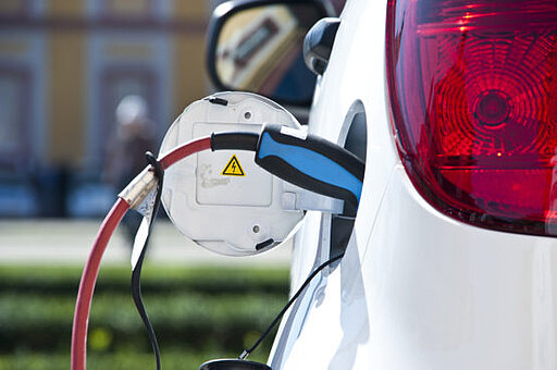Weißes Elektroauto wird geladen