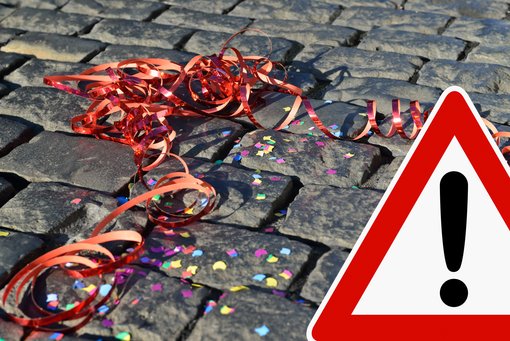 Auf einer Straße liegen Luftschlangen und Konfetti 