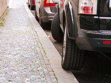 Rad von geparkten Auto steht auf spitzen Bordsteinkante