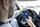 Eine Person, die in einem Auto sitzt, nutzt eine Smartphone-App, um die Parkgebühr zu bezahlen. Auf dem Bildschirm der App werden die Parkdaten angezeigt, während die Person mit einer Hand das Lenkrad und mit der anderen das Smartphone hält.