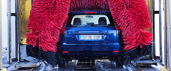 Blaues Auto ist in einer Waschanlage