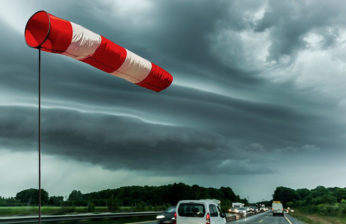 Ein rot weiß gestreifter Windsack bei einem Gewitter
