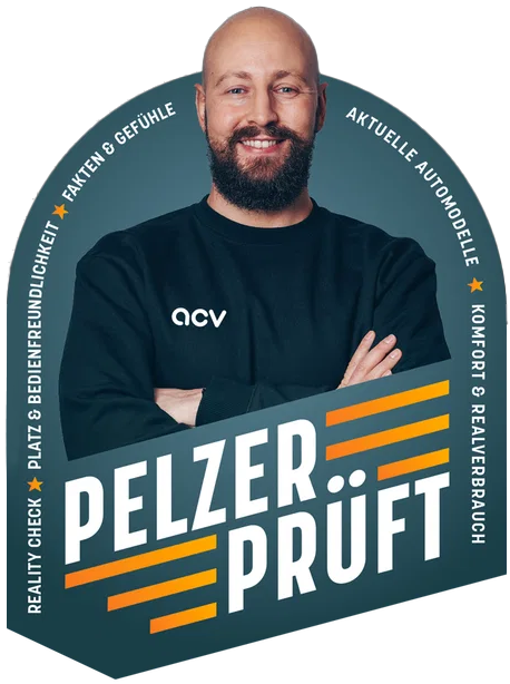 Ein lächelnder, bärtiger Mann mit verschränkten Armen, der ein dunkles Shirt mit ACV-Logo trägt, vor einem grafischen Bogen mit der Aufschrift „PELZER PRÜFT“ und verschiedenen deutschen Begriffen rund um Autotests und -berichte.