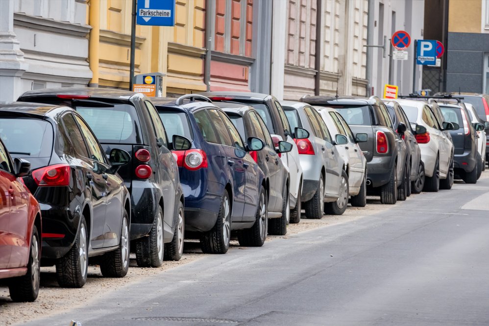 Parkende Autoreihen am linken Straßenrand