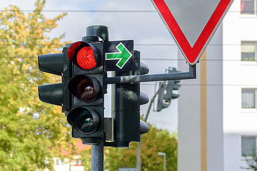 Verkehrsschild Grüner Pfeil an einer roten Ampel