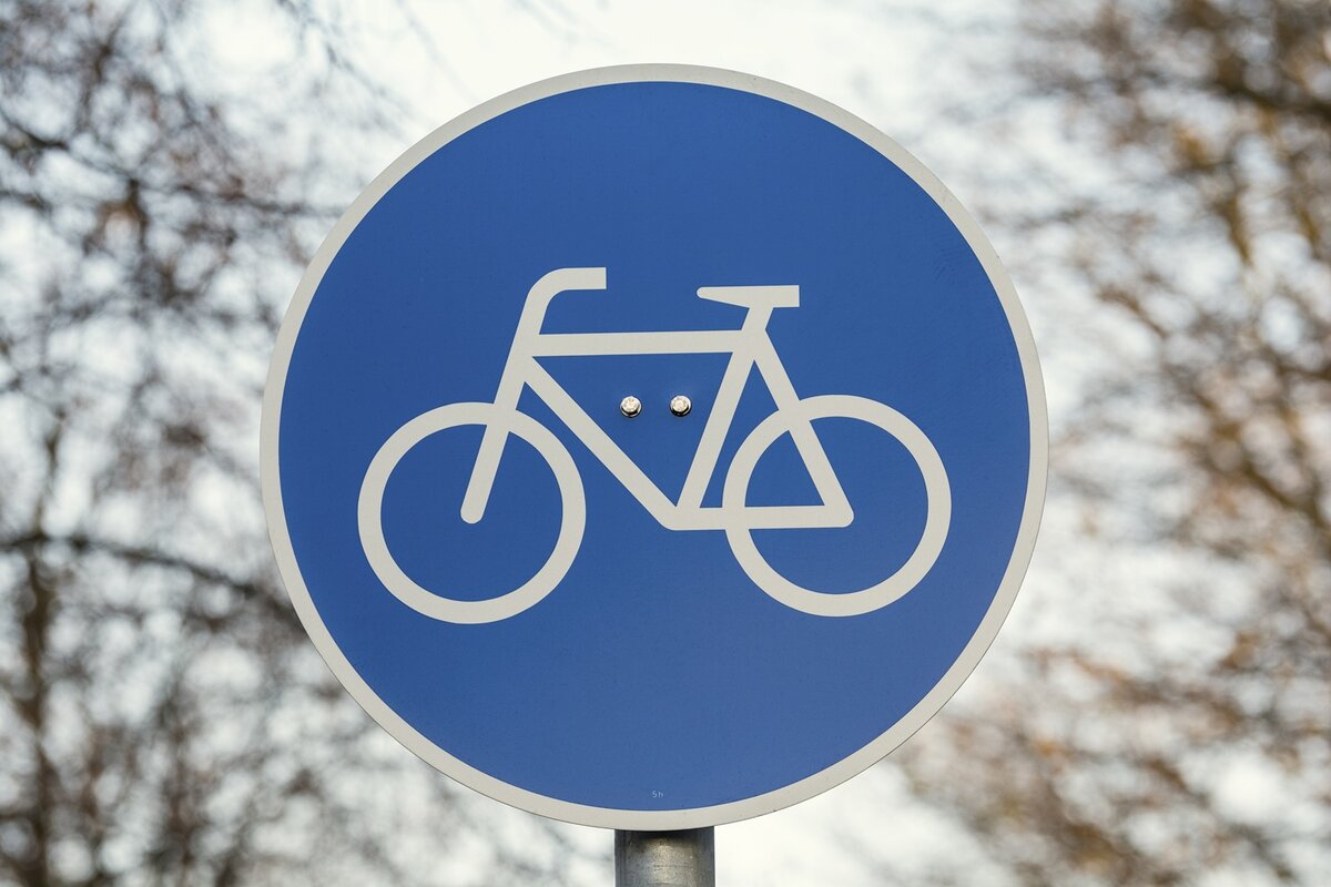 Ein blaues, rundes Schild mit einem weißen Fahrradsymbol, das einen ausgewiesenen Fahrradstreifen oder -weg kennzeichnet.