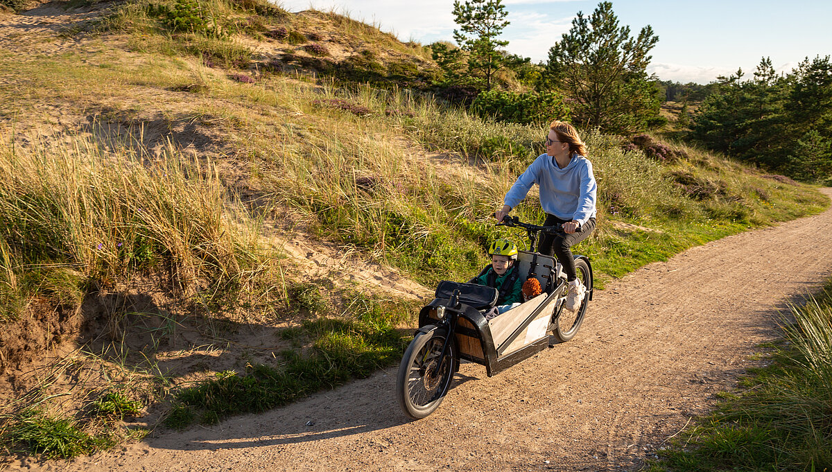 Frau fährt mit einem Lastenrad