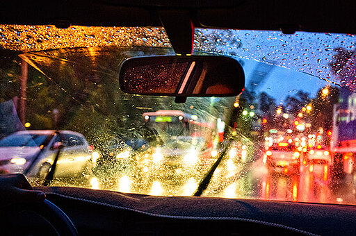 Ein Auto fährt im Dunkeln durch den Regen
