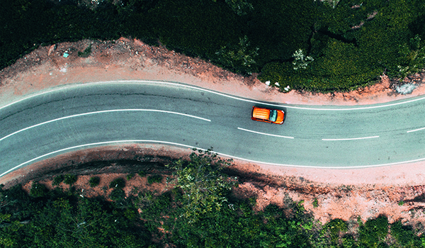 Kurvige Straße mit einem Auto aus der Vogelperspektive