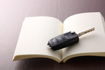 Ein aufgeschlagenes Buch und darauf liegt ein Autoschlüssel