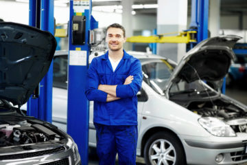 Kfz-Mechaniker steht in einer Werkstatt