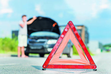 Warndreieck und dahinter ist ein Auto mit einer Panne