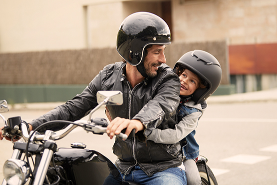 Mann fährt Motorrad mit Kind