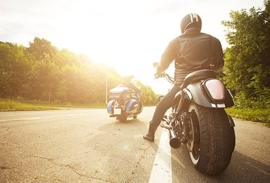 Motorrad steht bei Sonnenlicht auf dem Seitenstreifen