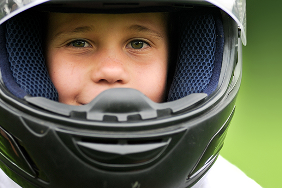 Kind trägt einen Motorradhelm