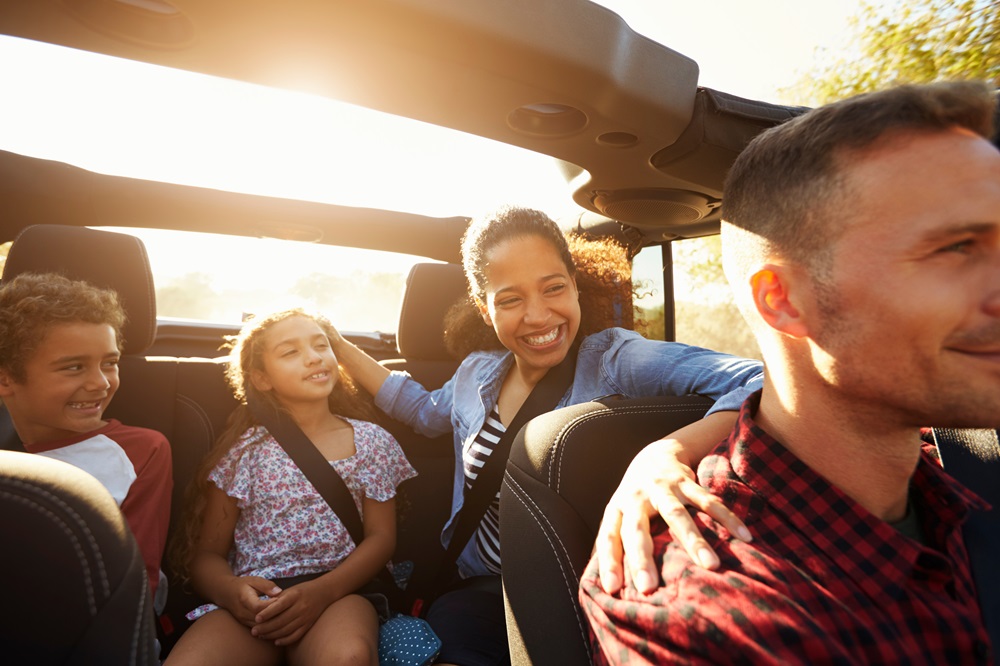 Eltern sitzen mit ihren Kindern im Auto