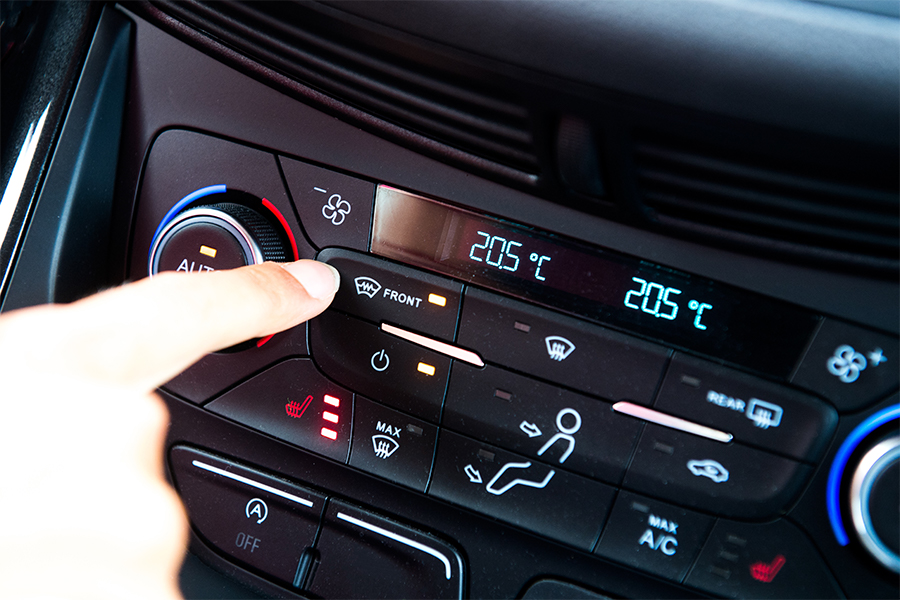Eine Person drückt einen Knopf im Innenraum eines Autos