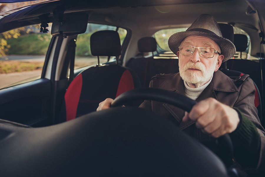 Ein Senior fährt Auto