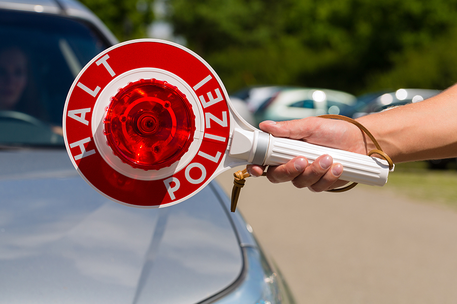 Polizeikelle vor einem silbernen Auto